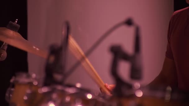 Spelar ett hi-hat musikinstrument. Musiker trummis händer håller trumma slå pinnar på en cymbal i en mörk hall, närbild. Cymbaler för trumvibration — Stockvideo