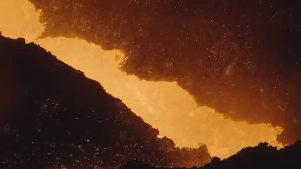 溶融黄橙色の金属は、飛んで火花でシュートを注ぎます。ファウンドリ制作。火山性の液体溶岩流が接近 — ストック動画