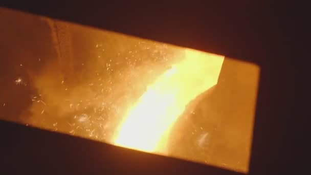Po skluzavce stéká proud roztaveného kovu, kouří a jiskří. Proces odlévání kovů, pohled za ochranný štít — Stock video