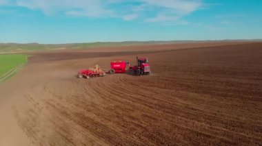 Tarımsal modern traktör ekin ekmeden önce toprağı sürüyor, toprağı ekime hazırlıyor, insansız hava aracının görüşü...