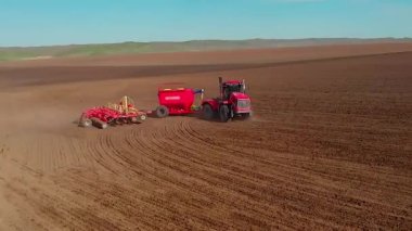 Tarımsal modern traktör ekin ekmeden önce toprağı sürüyor, toprağı ekime hazırlıyor, insansız hava aracının görüşü...