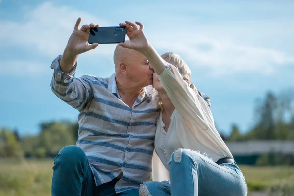 Mutlu yaşlı çiftler çıkıyor, selfie çekiyor ve dışarıda eğleniyorlar.