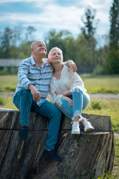 Mutlu son sınıf çifti güneşli bir günde parkta çıkıyor, sarılıyor ve konuşuyor.