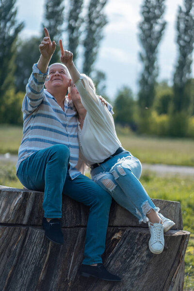 счастливая пожилая пара встречается, обнимается и разговаривает в парке в солнечный день