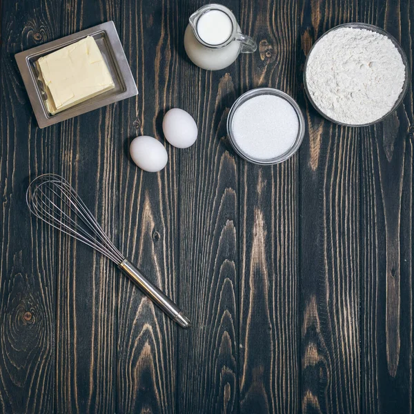 Vista superior de farinha, eegs, leite e açúcar na mesa na cozinha — Fotografia de Stock