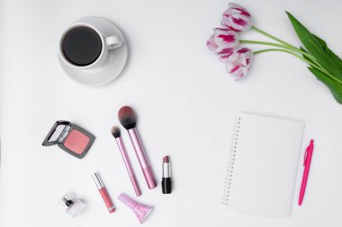 Kadın kozmetik ürünleri, kahve ve beyaz arka planda boş defter