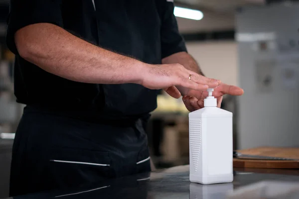 Şef Cook 'un işten önce dezenfeksiyon sıvısı antiseptik jel uygulamasını kapat.