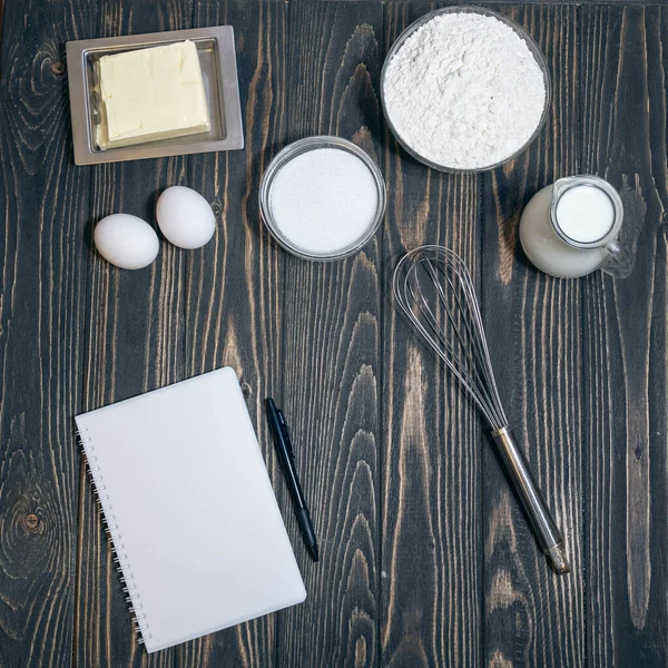 Rezeptbuch und Produkte zum Kuchen- oder Kuchenbacken auf dem Schreibtisch in der Küche — Stockfoto