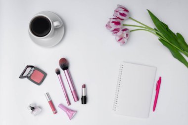Kadın kozmetik ürünleri, kahve ve beyaz arka planda boş defter