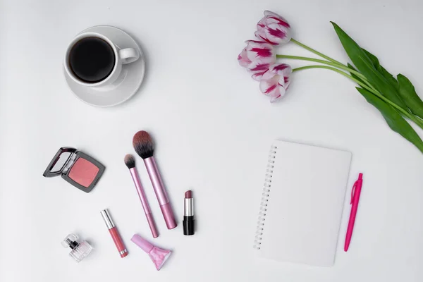 Kadın kozmetik ürünleri, kahve ve beyaz arka planda boş defter
