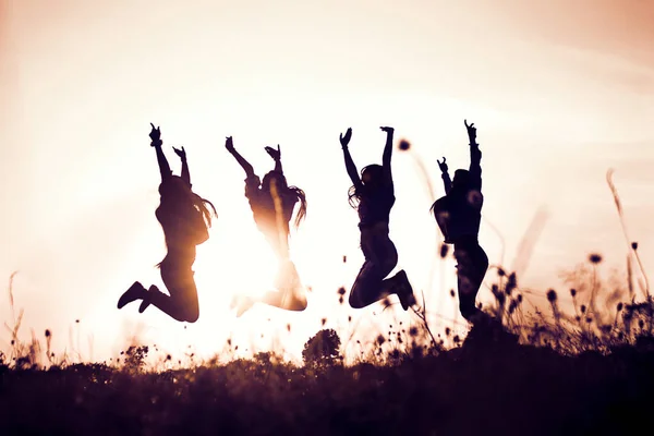 Gökyüzüne karşı kutlama yapan gençlerin silueti. Mutlu kadın duvar kağıtları .