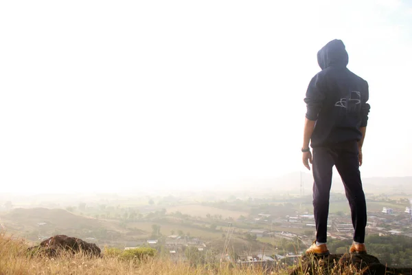 Dağın tepesinde duran genç adam. metin alanı.