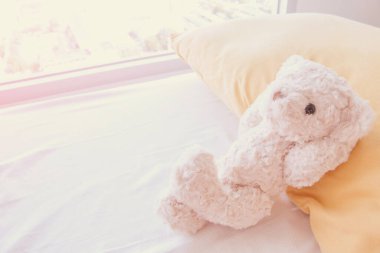 Sevimli küçük oyuncak ayı yatağa uzanıyor..