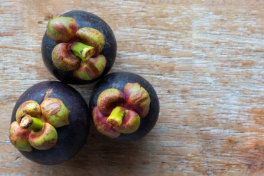 Ahşap arka planda taze mangosen, olgun meyveler tatlı bir lezzet