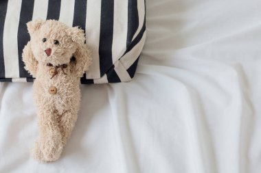 Oyuncak ayının siyah beyaz kumaşta rahatlaması, rahatlatıcı bir konsept..