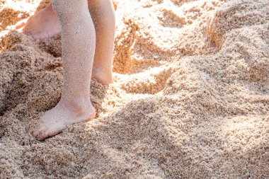 İki insan kumun üzerinde, kırpılmış atış