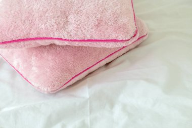 Pembe yumuşak yastıklar beyaz yatak çarşafları üzerinde