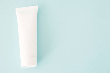 Mavi arka planda beyaz kozmetik şişe