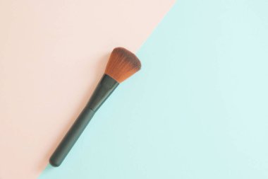 Makyaj fırçası pembe ve mavi kağıt üzerinde, üst görünüm