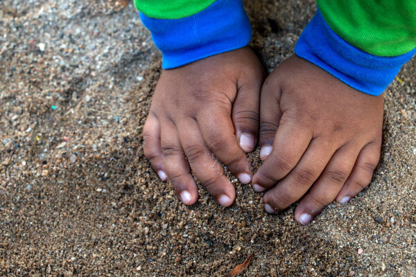 hands of child playing with sand