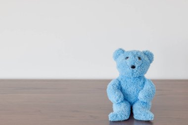 Oyuncak ayı tahta sandalyede oturuyor.