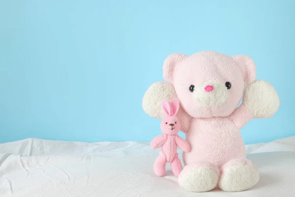 Osito Peluche Con Juguete Conejo Rosa Sobre Fondo Azul Fotos de stock libres de derechos