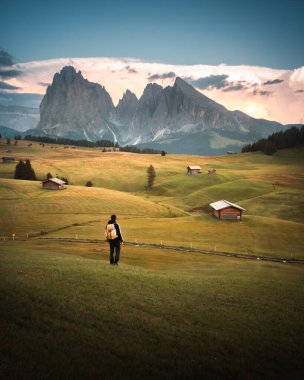 Sırt çantalı Alpe di Siusi 'de günbatımının tadını çıkarıyor