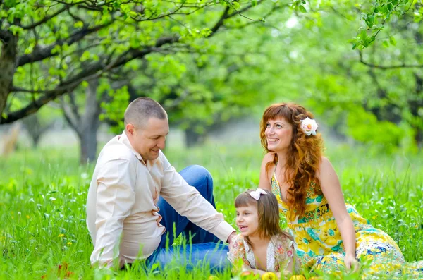 Mãe, pai e filha andando no jardim verde — Fotografia de Stock