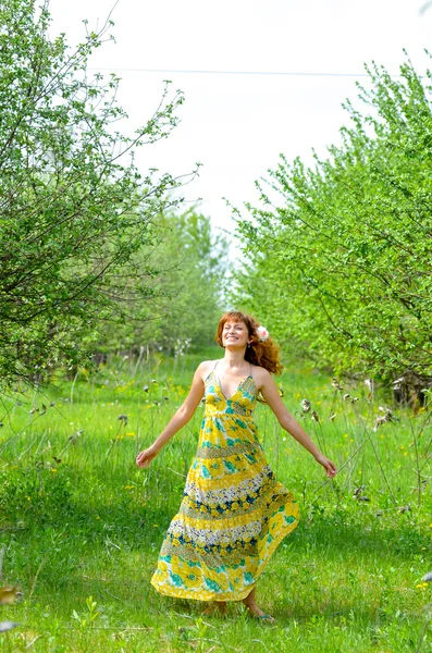 Jovem menina bonita caminha no pomar de maçã verde primavera — Fotografia de Stock