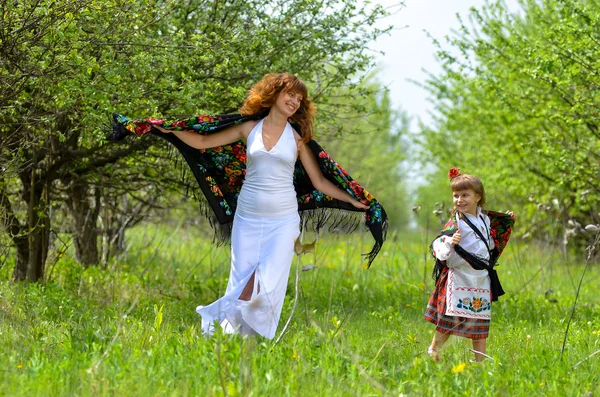 Jovem bela mãe andando com sua filha no jardim — Fotografia de Stock