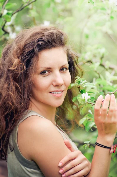 Belle jeune fille debout près de l'arbre en fleurs — Photo