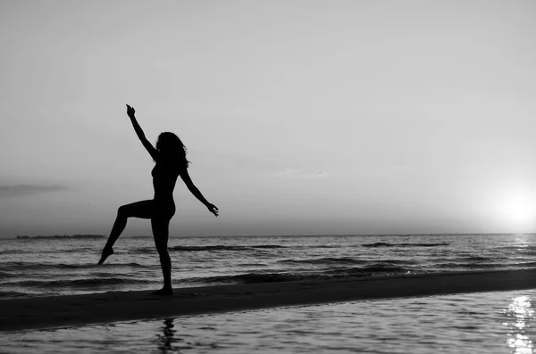 Chica haciendo gimnasia en la playa al atardecer — Foto de Stock