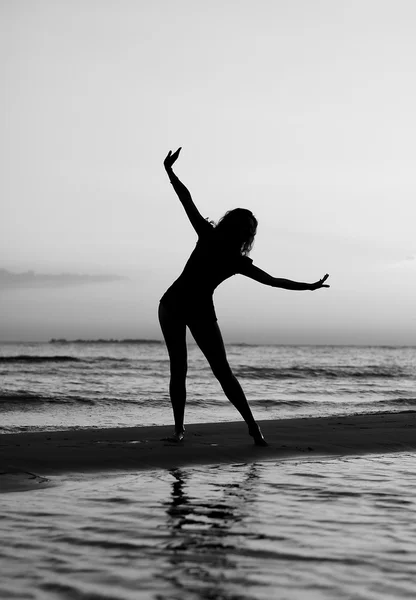 Girl doing gymnastics on the beach at sunset — Stock Photo, Image