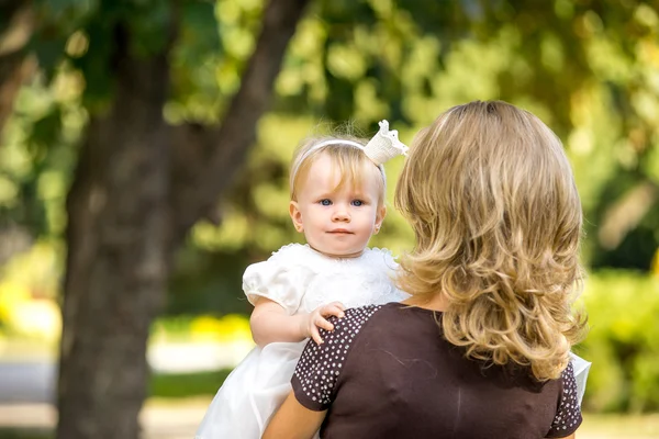 Mãe caminha com a criança no jardim no verão . — Fotografia de Stock