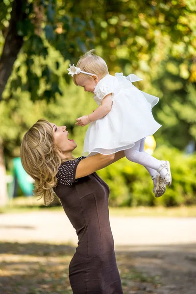 Mãe caminha com a criança no jardim no verão . — Fotografia de Stock