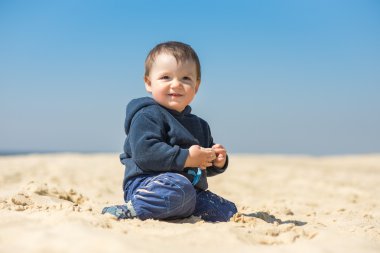 küçük çocuk kumsalda yürür