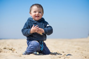 küçük çocuk kumsalda yürür