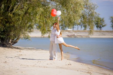 İlkbahar, yaz sahilde oturan adamla mutlu kız.