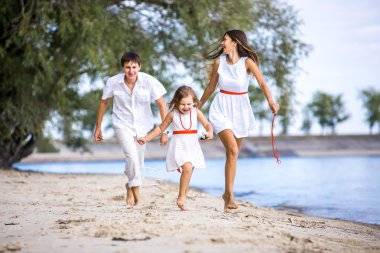 Anne, baba ve kızı Sahilde yürüyüş