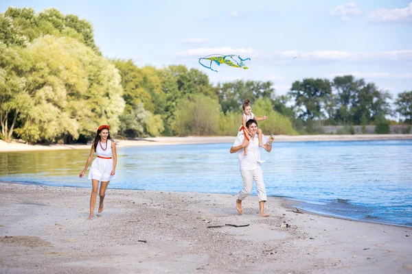 Mom, dad and daughter walking on the beach — Stock Photo, Image