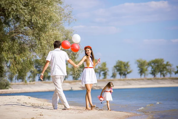 Mamma, papà e figlia che camminano sulla spiaggia — Foto Stock