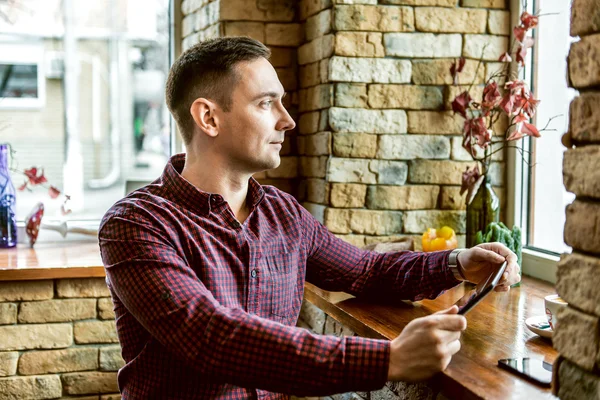 kafede oturan ve pencereden dışarı bakarak insanlar