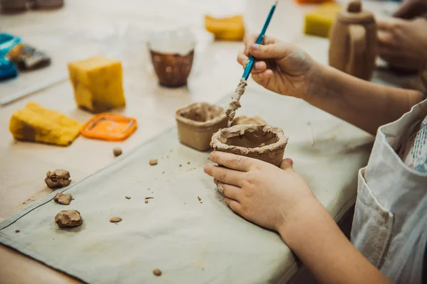 Niño esculpe el producto de arcilla cruda — Foto de Stock