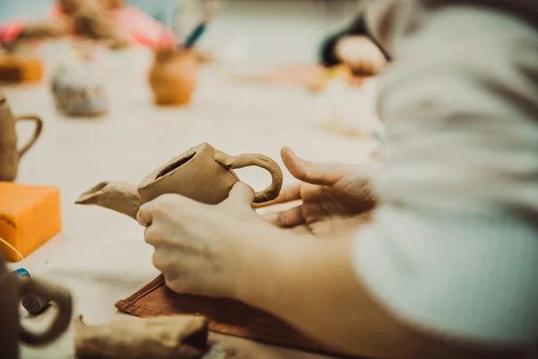 Child sculpts the product from raw clay — Stock Photo, Image