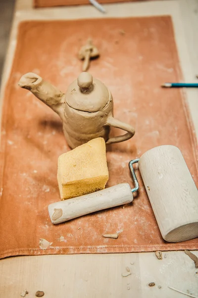 On the table is a jug of unbaked clay — Stock Photo, Image