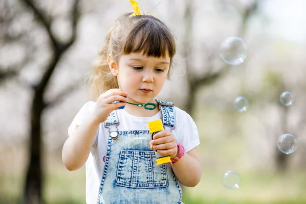 Menina infla bolhas de sabão — Fotografia de Stock