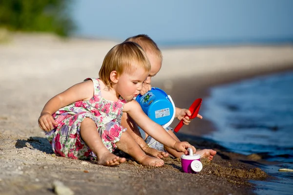 Kleine Kinder spazieren im Sommer am Strand — Stockfoto