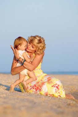 Kumsalda oynarken kızı olan anne