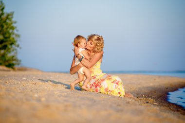 Kumsalda oynarken kızı olan anne