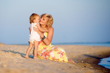 Kumsalda oynarken kızı olan anne